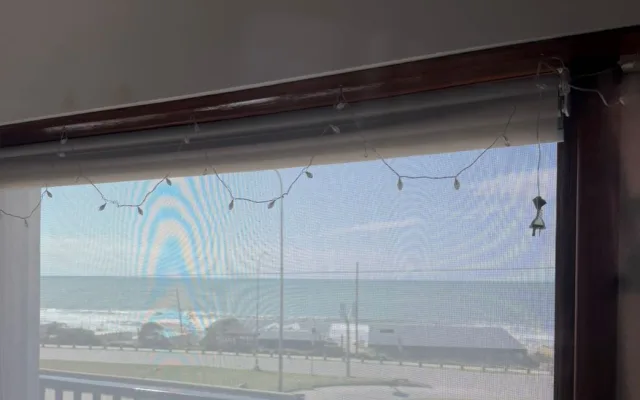 Cortina roller en un balcón con vista al mar