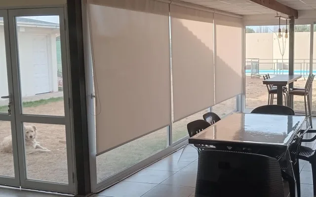 Cortinas roller cerrando una galería con pileta